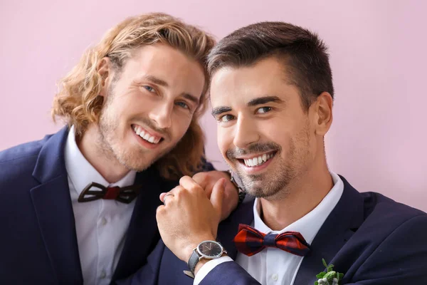 Portré boldog meleg pár az esküvő napján szemben színes háttér — Stock Fotó