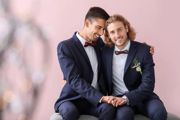 Portrait of happy gay couple on their wedding day against color background — Stock Photo, Image