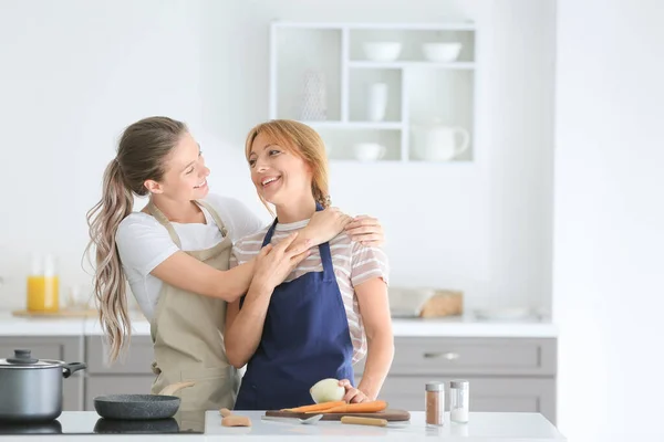 Young woman and her mother cooking together in kitchen — Stock Photo, Image