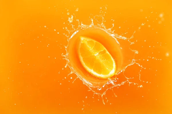 Chute du morceau d'orange dans le jus, vue du dessus — Photo
