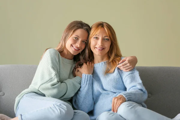 Happy mother and daughter sitting on sofa at home — Stock Photo, Image