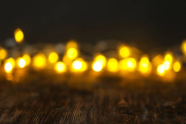 Vista de perto da mesa de madeira com luzes embaçadas — Fotografia de Stock