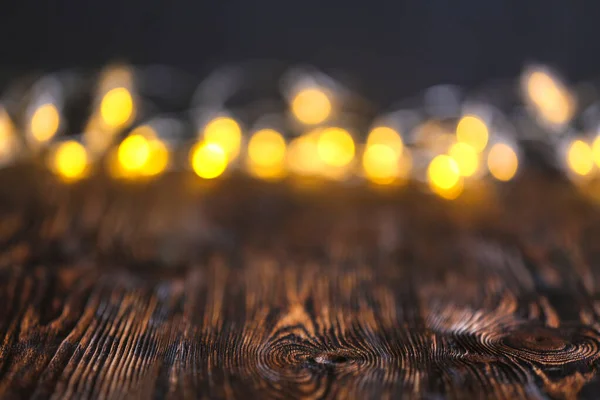 Vista de perto da mesa de madeira com luzes embaçadas — Fotografia de Stock