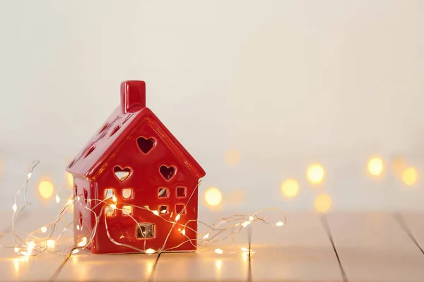 Small house with glowing garland on white table — Stock Photo, Image