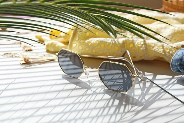 Elegantes gafas de sol femeninas con ropa sobre fondo blanco — Foto de Stock