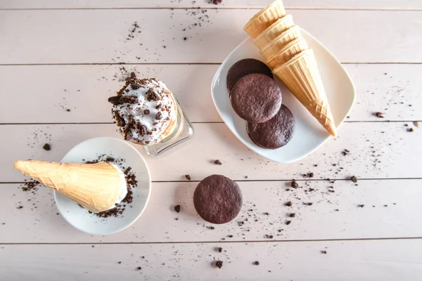 Wafer cones with tasty ice cream and chocolate cookies on table — Stock Photo, Image
