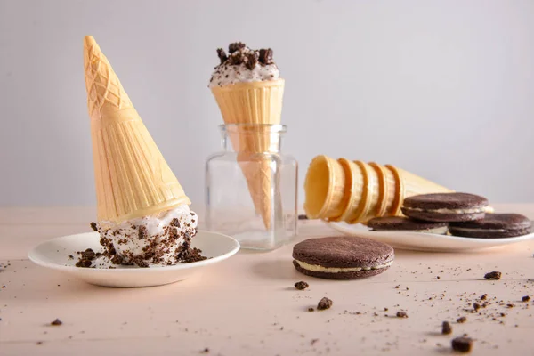 Вафельні шишки зі смачним морозивом та шоколадним печивом на столі — стокове фото