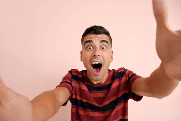 Překvapený mladý muž na barevném pozadí — Stock fotografie