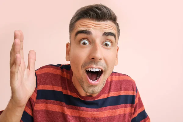 Surprised young man on color background — Stock Photo, Image