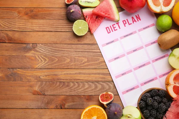 Different healthy food with diet plan on wooden table — Stock Photo, Image