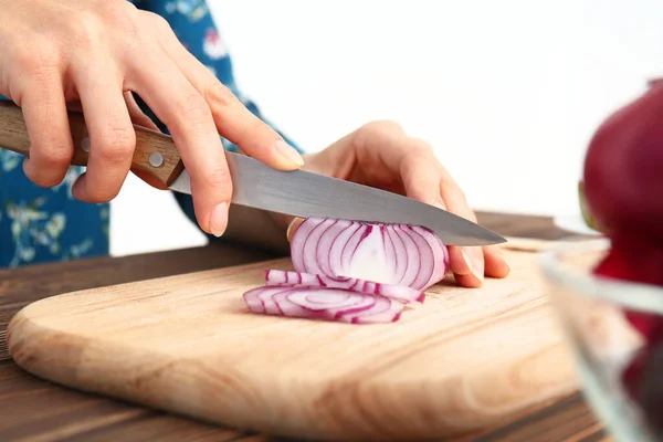 Woman cutting onion in kitchen, closeup — Stock Photo, Image