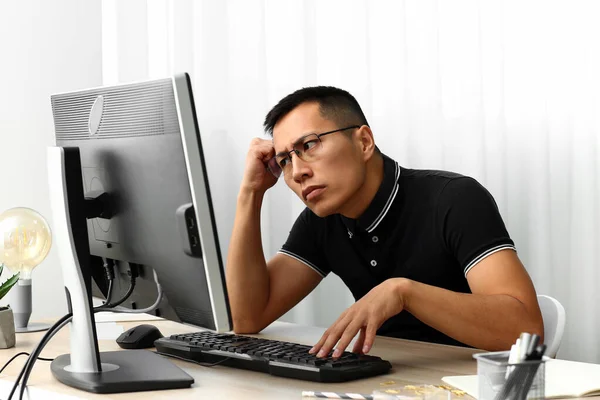 Азиатский программист, работающий на компьютере в офисе — стоковое фото
