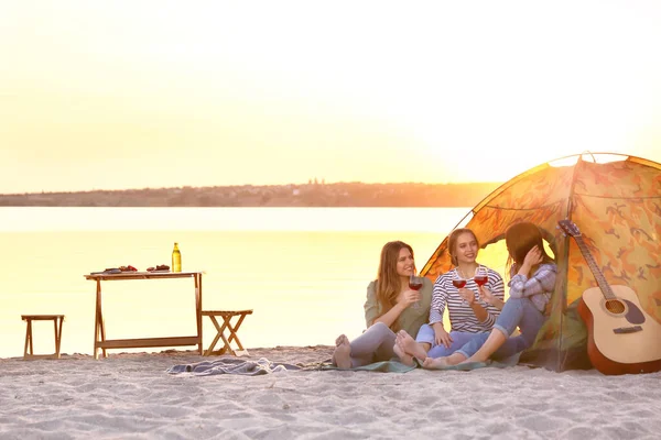 Young women having picnic near river — Stock Photo, Image