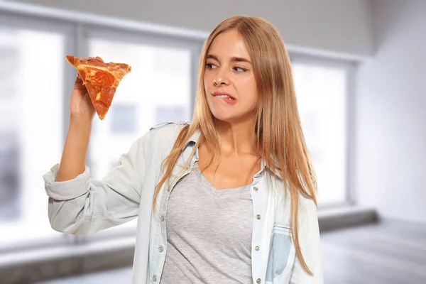 Mujer joven con rebanada de deliciosa pizza en casa —  Fotos de Stock