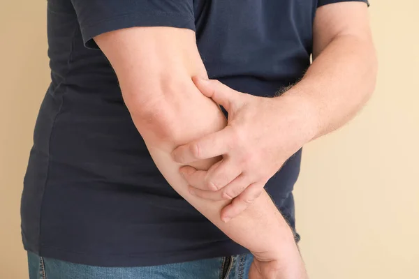 Senior man suffering from pain in elbow on light background, closeup — Stock Photo, Image