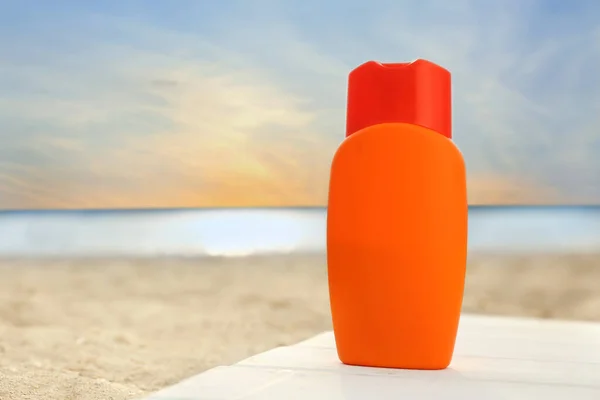 Botella de crema protector solar en la playa de mar —  Fotos de Stock