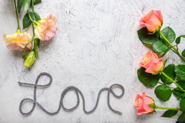 Çiçekli kompozisyon ve açık arkaplanda aşk kelimesi