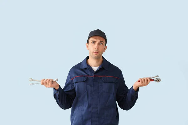 Confused car mechanic on color background — Stock Photo, Image