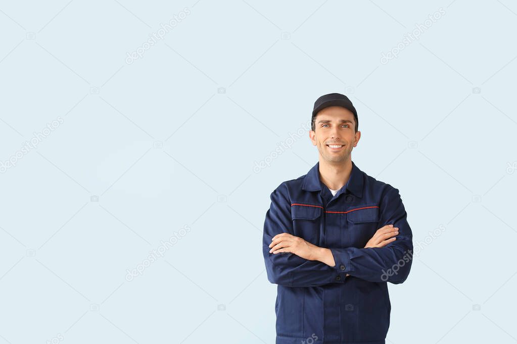 Male car mechanic on color background