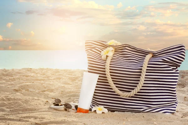 Beach bag and sunscreen cream on sea coast — Stock Photo, Image