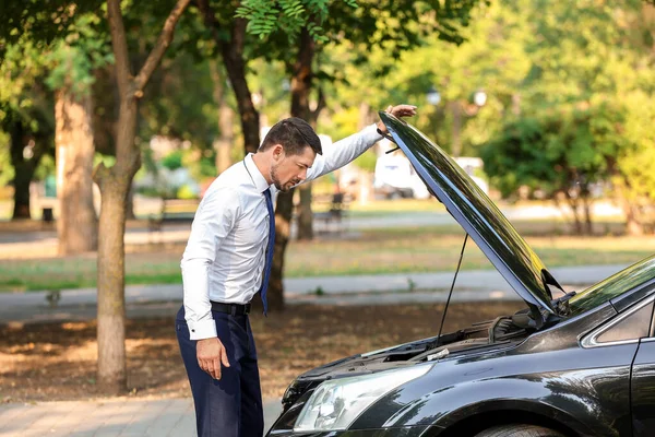 Наголошений бізнесмен поблизу розбитого автомобіля на відкритому повітрі — стокове фото