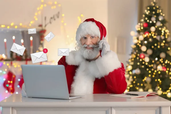 Święty Mikołaj rozmawiający przez telefon komórkowy podczas sprawdzania e-maila w domu — Zdjęcie stockowe