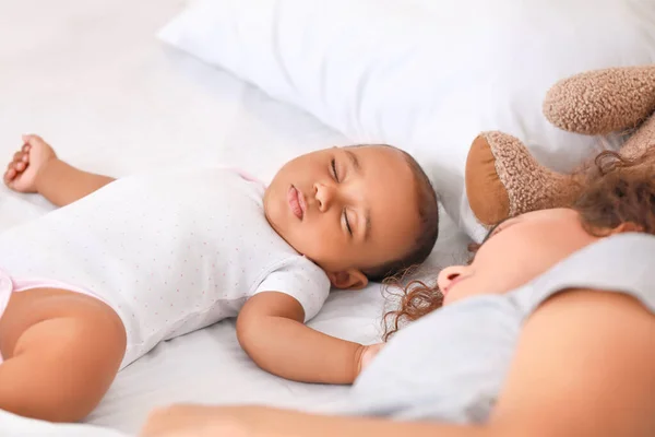 Genç Afro-Amerikalı kadın ve bebeği yatakta uyuyor — Stok fotoğraf