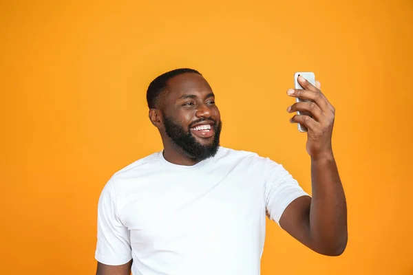 Feliz hombre afroamericano tomando selfie sobre fondo de color — Foto de Stock
