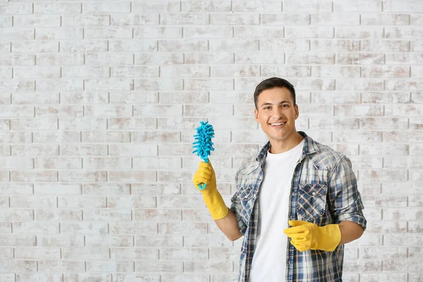 Young man with brush against brick wall — Stock Photo, Image