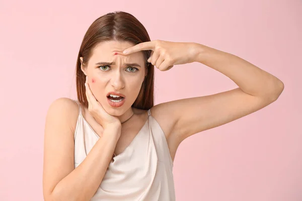 Portrait of young woman with acne problem on color background — Stock Photo, Image