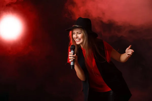 Linda jovem cantora com microfone no palco — Fotografia de Stock