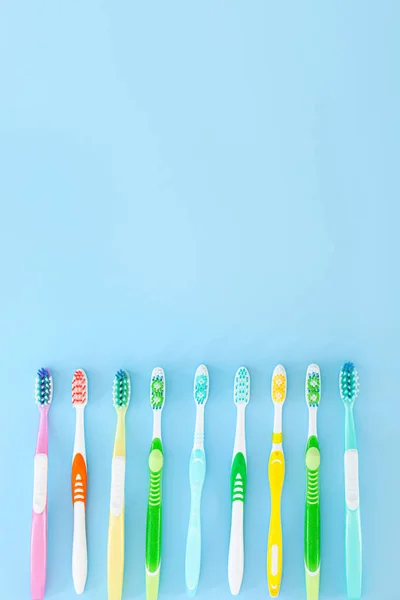 Many tooth brushes on color background — Stock Photo, Image