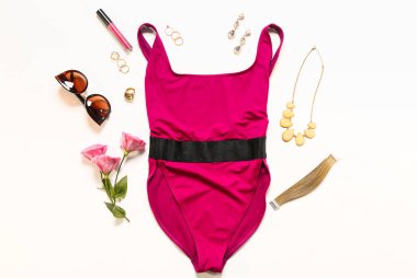 Beyaz arka planda aksesuarları olan şık bir kadın mayosu.