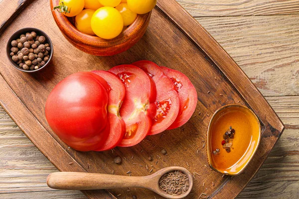 Deska ze świeżymi pomidorami i przyprawami na drewnianym stole — Zdjęcie stockowe