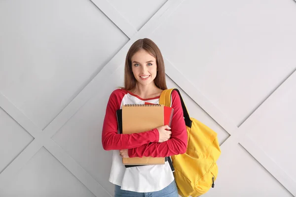 Female student on light background — Stock Photo, Image