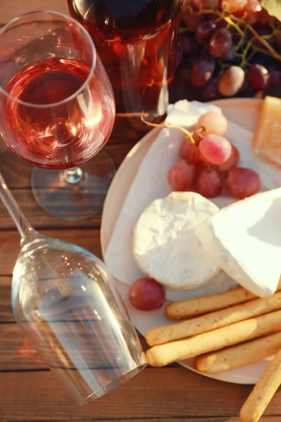 Bicchieri con vino e snack sul tavolo di legno — Foto Stock