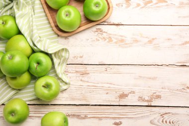 Hafif ahşap zemin üzerinde taze olgun elmalar