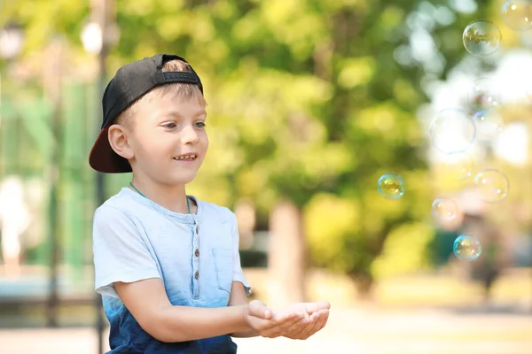 Söt liten pojke leker med såpbubblor i parken — Stockfoto