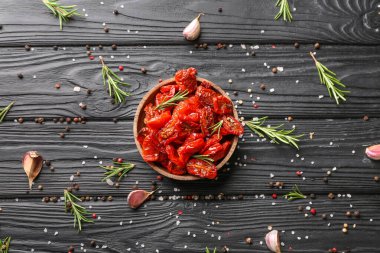 Ahşap masada kurutulmuş domates ve baharat tabağı.