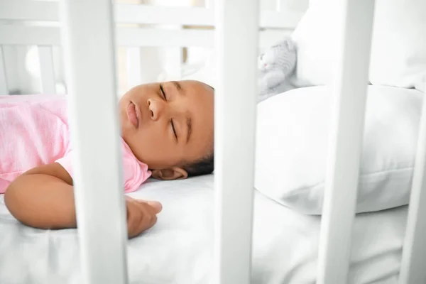 Pequeno bebê afro-americano dormindo na cama, vista através do corrimão — Fotografia de Stock