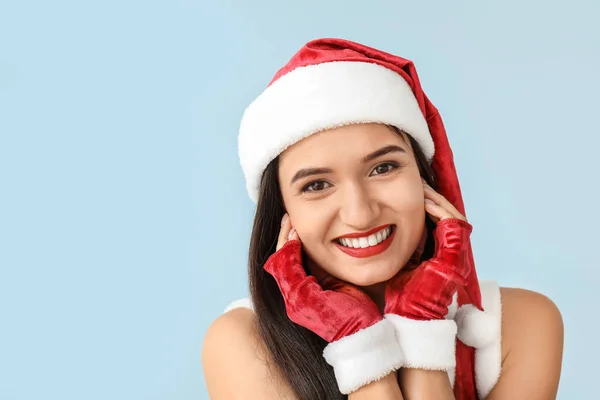 Mooie jonge vrouw in Santa Claus kostuum op lichte achtergrond — Stockfoto