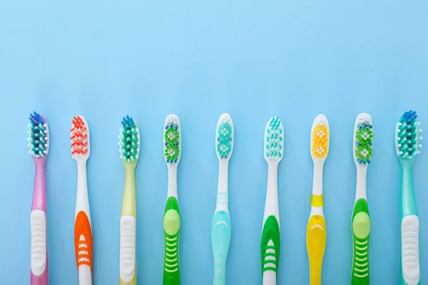 Many tooth brushes on color background — Stock Photo, Image