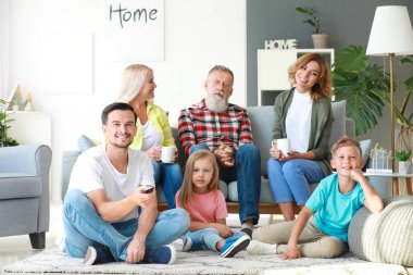 Büyük aile evde birlikte Tv izliyor