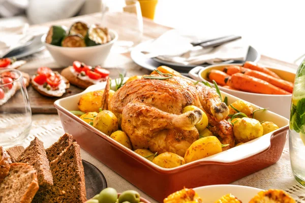 Naczynie do pieczenia ze smacznym kurczakiem i ziemniakami na stole — Zdjęcie stockowe