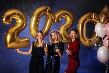 Güzel genç kadınlar Noel partisinde şampanya içiyorlar.