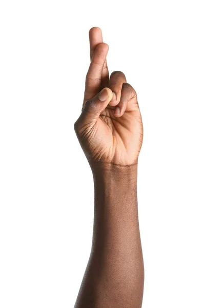 Hand of African-American man with crossed fingers on white background — Stock Photo, Image