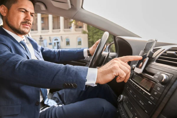 Uomo d'affari che utilizza il telefono cellulare per la navigazione durante la guida di auto — Foto Stock