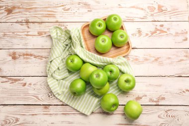 Hafif ahşap zemin üzerinde taze olgun elmalar