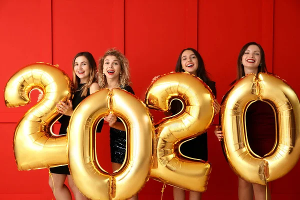 Belle giovani donne con palloncini alla festa di Natale — Foto Stock