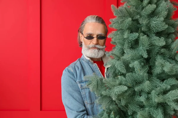 Porträt von stilvollen Weihnachtsmann mit Weihnachtsbaum auf farbigem Hintergrund — Stockfoto